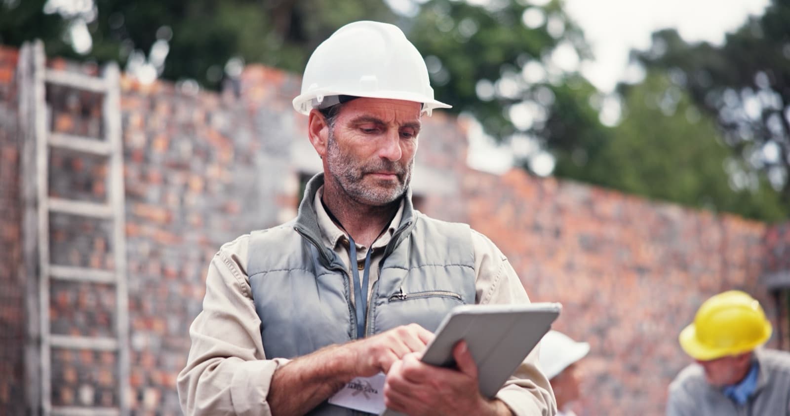 Contractor reviewing project details on a tablet at a California job site